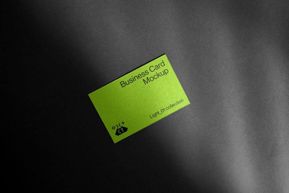 Bright lime green business card at angle on dark gray surface